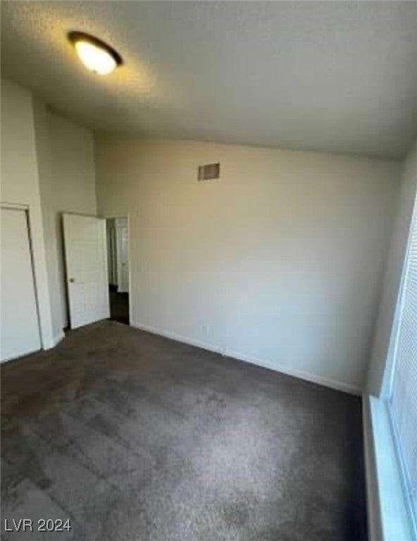 carpeted empty room featuring a textured ceiling