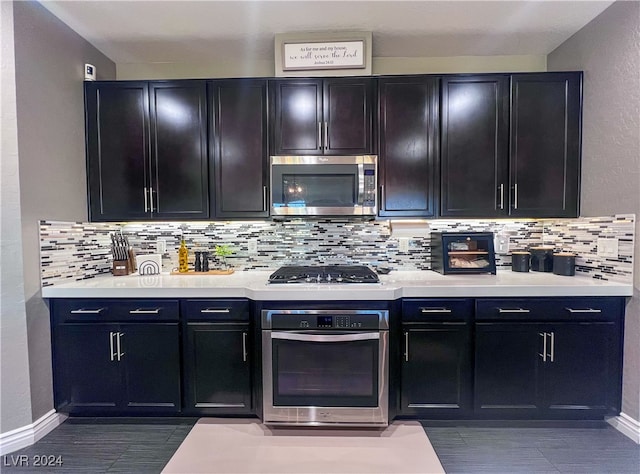 kitchen with appliances with stainless steel finishes and backsplash