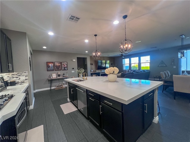 kitchen featuring hanging light fixtures, dishwasher, a center island with sink, and a notable chandelier