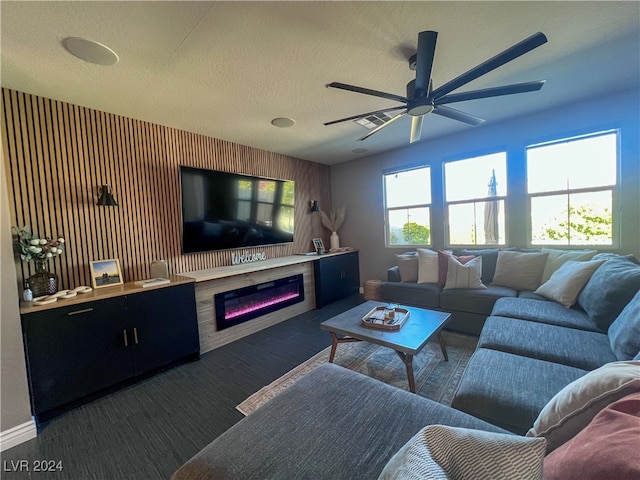 living room featuring ceiling fan and a textured ceiling