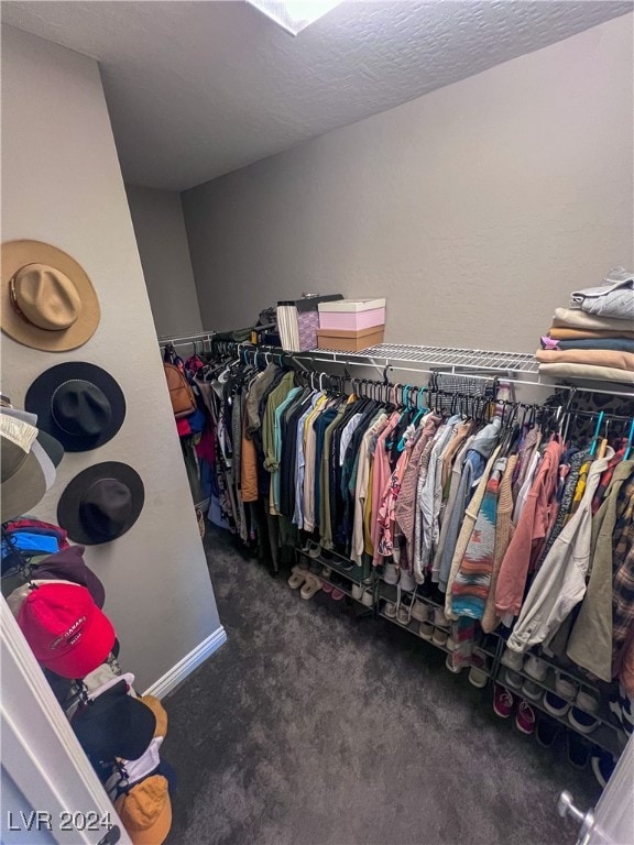 spacious closet featuring dark colored carpet