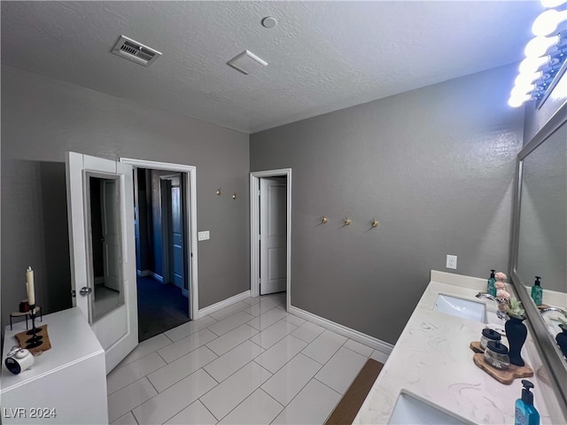 bathroom featuring a textured ceiling, vanity, and tile patterned floors