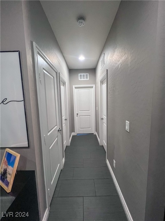 hallway featuring dark tile patterned flooring