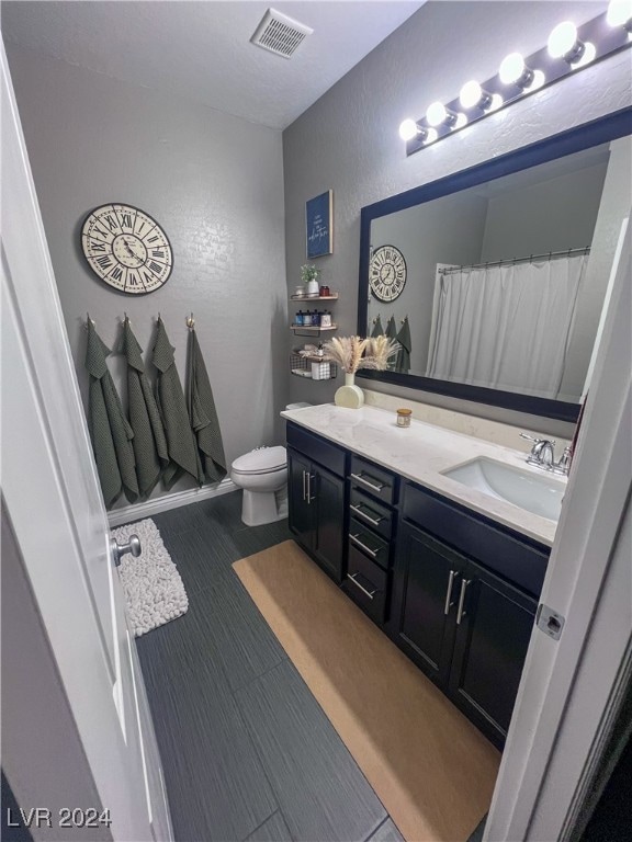 bathroom with a shower with shower curtain, toilet, and vanity