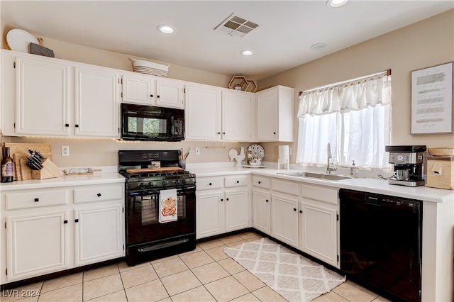 kitchen featuring black appliances, sink, light tile patterned floors, and white cabinets