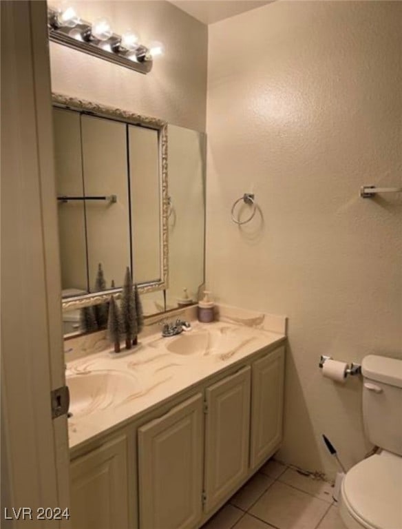 bathroom with tile patterned flooring, vanity, and toilet