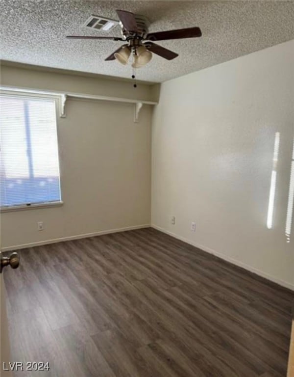 unfurnished room featuring a textured ceiling, ceiling fan, and dark hardwood / wood-style flooring