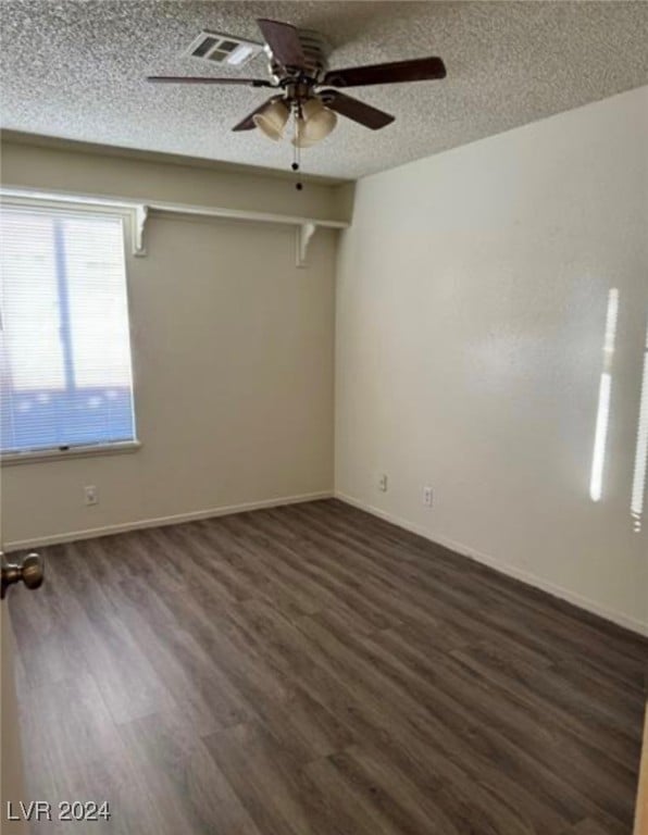 unfurnished room featuring a textured ceiling, dark wood-type flooring, and ceiling fan