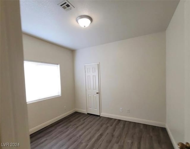 spare room with dark wood-type flooring