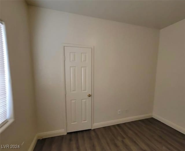 unfurnished room featuring dark wood-type flooring