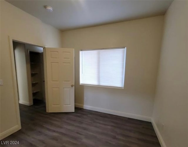 unfurnished bedroom featuring a closet and dark hardwood / wood-style flooring