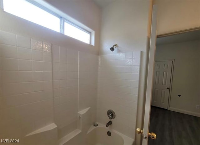 bathroom with tiled shower / bath combo and hardwood / wood-style floors