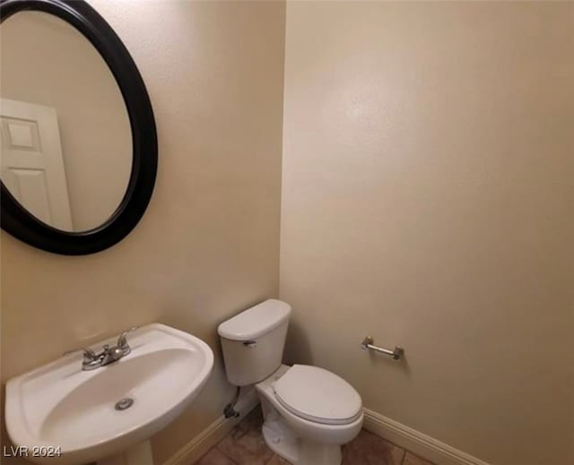 bathroom featuring toilet, sink, and tile patterned floors