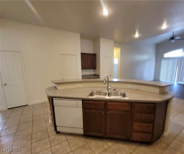 kitchen featuring dishwasher, light tile patterned floors, sink, and dark brown cabinetry