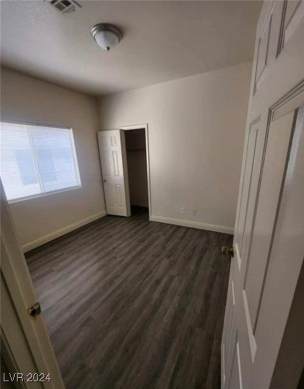 unfurnished bedroom with dark wood-type flooring