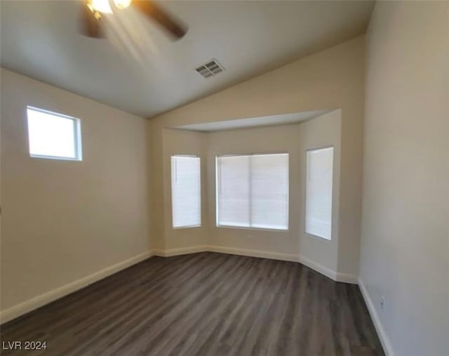 spare room with ceiling fan, vaulted ceiling, and dark hardwood / wood-style flooring