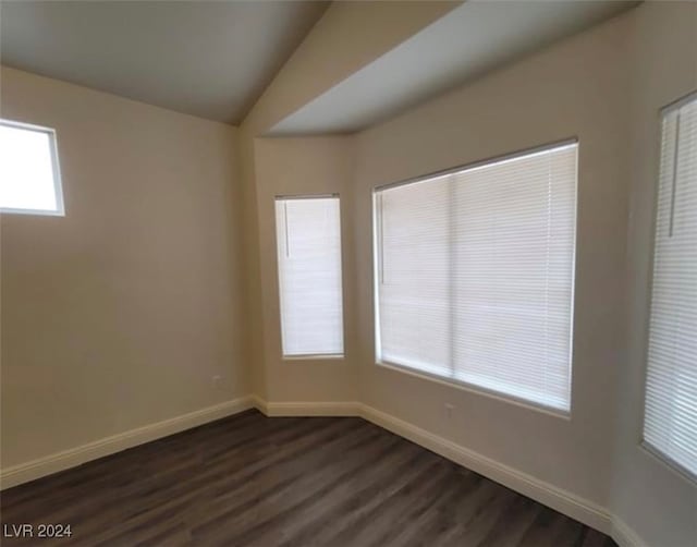 empty room with lofted ceiling and dark hardwood / wood-style flooring