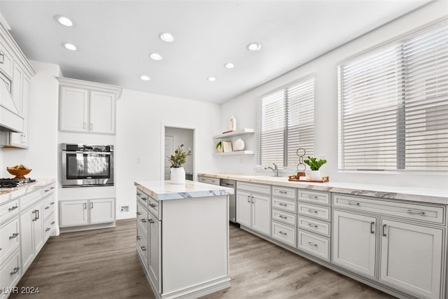 kitchen featuring appliances with stainless steel finishes, sink, a kitchen island, and light hardwood / wood-style flooring