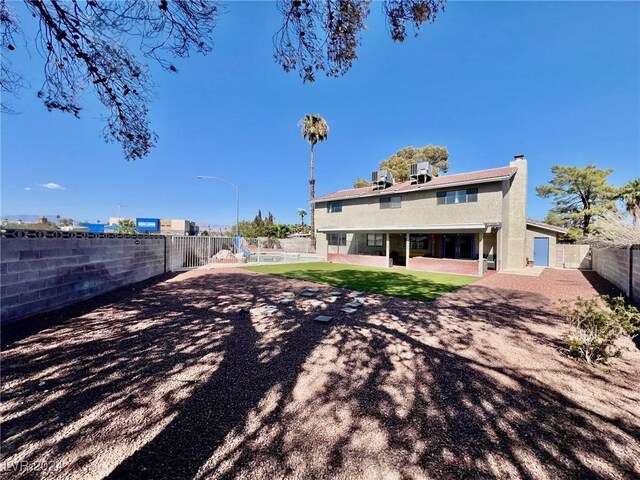 back of property featuring a patio and a yard