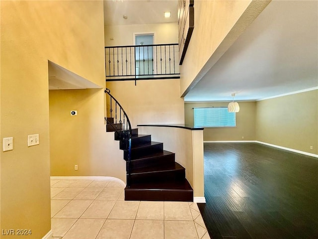 staircase featuring hardwood / wood-style floors and a high ceiling