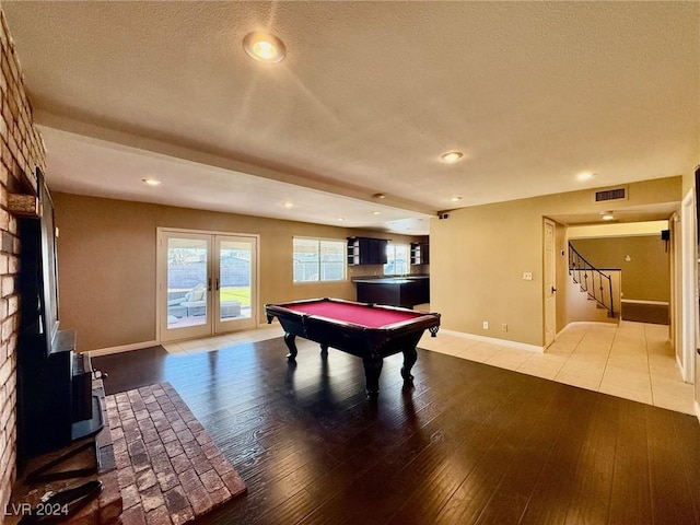 playroom with pool table, light hardwood / wood-style flooring, french doors, and a textured ceiling