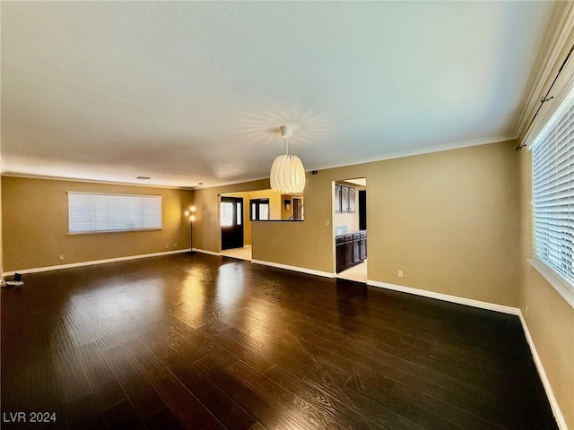 empty room with crown molding and wood-type flooring