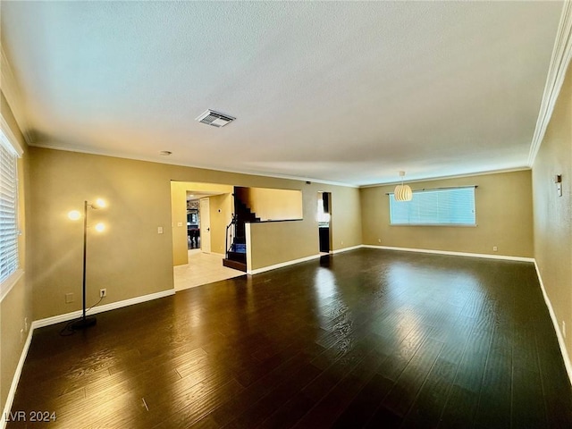 empty room with ornamental molding and hardwood / wood-style floors