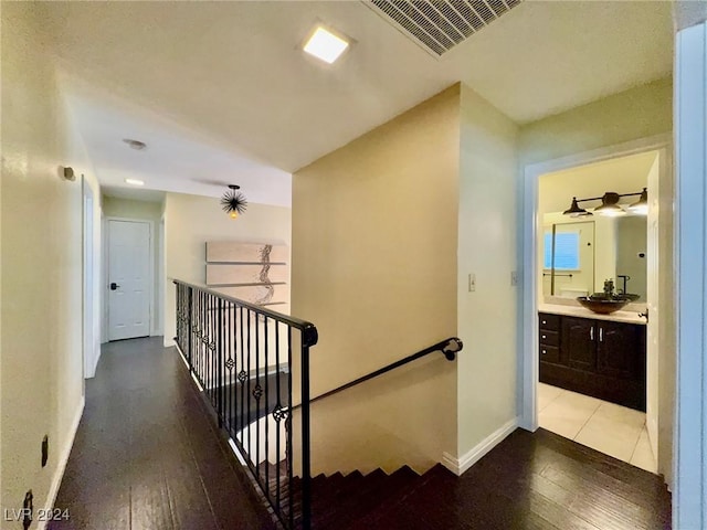 staircase with wood-type flooring and sink