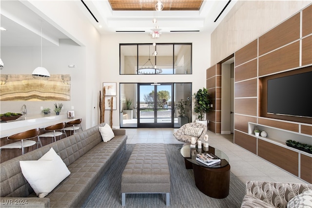 tiled living room with a high ceiling and a tray ceiling