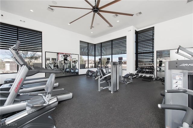 gym with ceiling fan and a towering ceiling