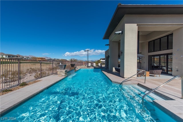 view of swimming pool featuring pool water feature and a patio