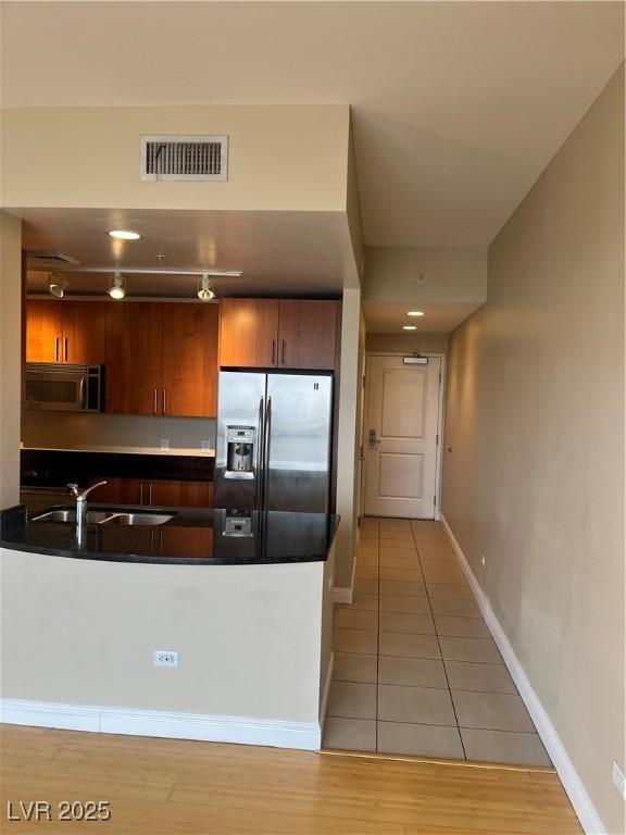 kitchen featuring appliances with stainless steel finishes, sink, and light tile patterned floors