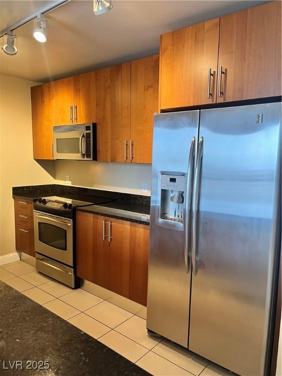 kitchen with light tile patterned floors, rail lighting, and appliances with stainless steel finishes