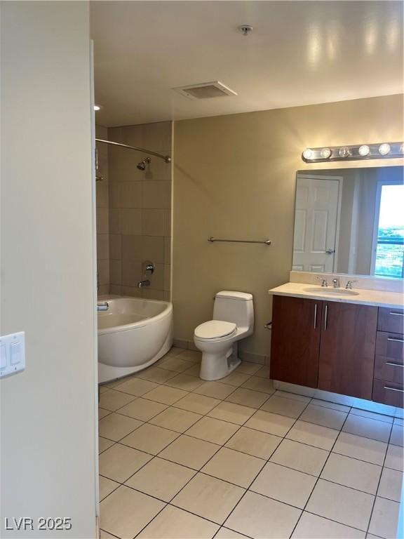 full bathroom with tile patterned flooring, vanity, tiled shower / bath combo, and toilet