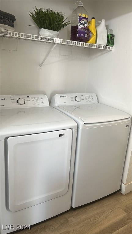 laundry room with hardwood / wood-style flooring and separate washer and dryer