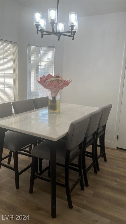 dining area with hardwood / wood-style flooring and a notable chandelier