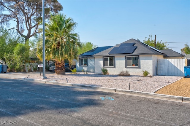 ranch-style house featuring solar panels