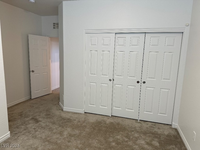 unfurnished bedroom with carpet and a closet