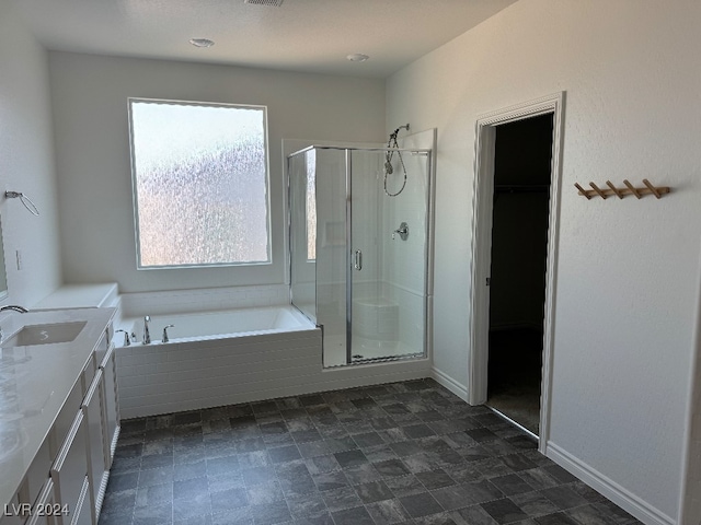 bathroom featuring a wealth of natural light, vanity, and independent shower and bath