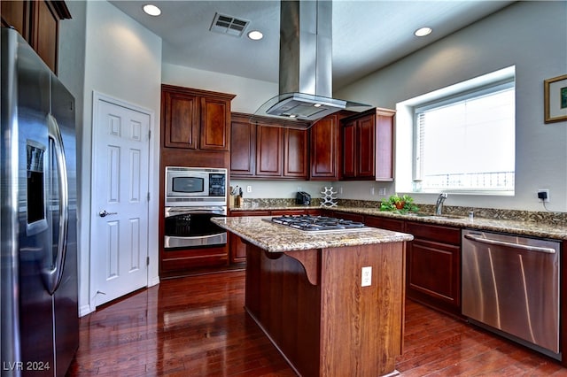 kitchen with stainless steel appliances, dark hardwood / wood-style flooring, a kitchen island, light stone countertops, and island exhaust hood