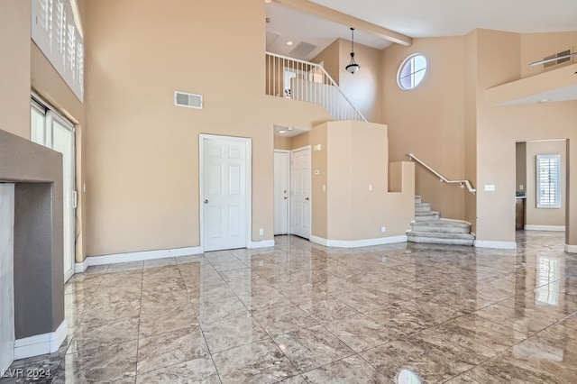 unfurnished living room featuring beamed ceiling and high vaulted ceiling