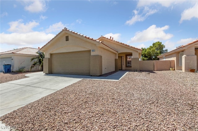 mediterranean / spanish-style house with driveway, a garage, a tiled roof, fence, and stucco siding