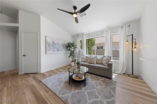 living room featuring ceiling fan, vaulted ceiling, and light hardwood / wood-style flooring