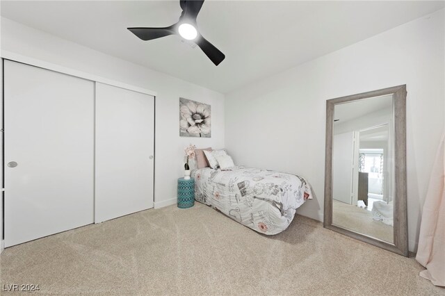 bedroom featuring a closet, ceiling fan, and light colored carpet