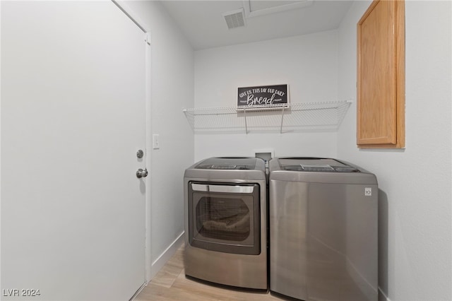 washroom featuring washer and clothes dryer and light wood-type flooring