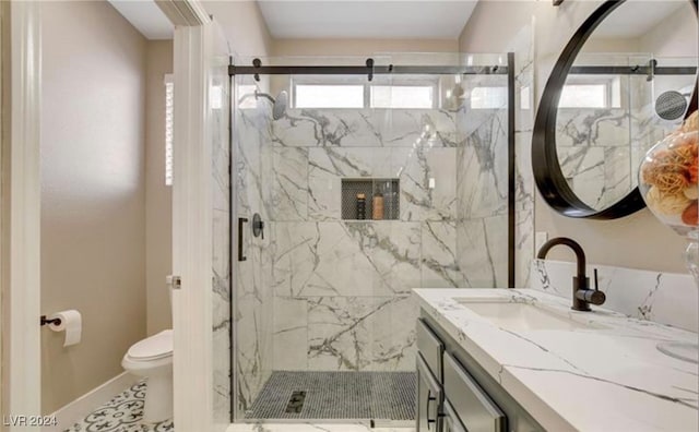 bathroom featuring vanity, a healthy amount of sunlight, toilet, and a shower with shower door