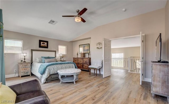 bedroom with ceiling fan, vaulted ceiling, light wood-type flooring, and multiple windows