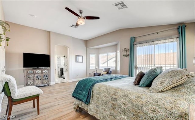 bedroom with light wood-type flooring, ensuite bathroom, ceiling fan, and lofted ceiling