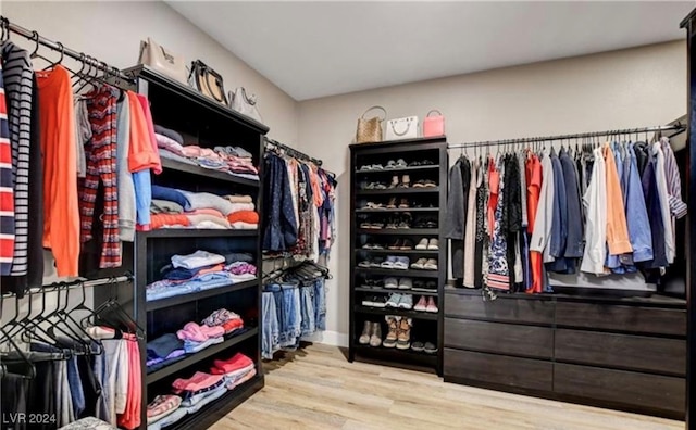 walk in closet with light hardwood / wood-style floors