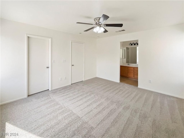 unfurnished bedroom featuring visible vents, ensuite bath, baseboards, and carpet floors